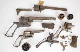 A collection of pinfire revolver parts including some near complete, frames, cylinders etc,