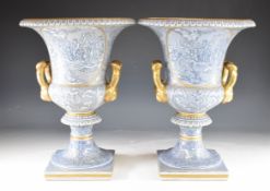 Pair of twin handled pedestal porcelain urns decorated with classical scenes in relief, H40cm