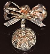 A silver brooch in the form of a bow and flower with applied 14k gold decoration, verso a locket