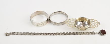 Two hallmarked silver bangles (45g, one Chester 1942), hallmarked silver tea strainer (32g) and a