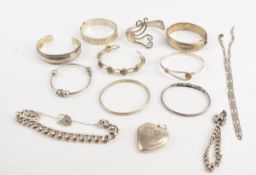 Eight silver bangles, two curb link bracelets, a heart shaped silver locket, Pandora bracelet and