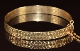 A 9ct gold bangle with cut out decoration, 14.2g, 5.8 x 5.2cm