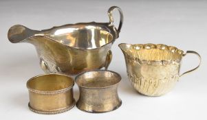 Elizabeth II hallmarked silver sauce boat with shaped edge, scroll handle and three plain feet,