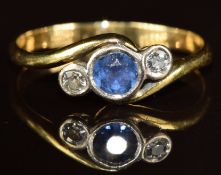 An 18ct gold ring set with a sapphire and two diamonds in a crossover design, 2.5g, size O