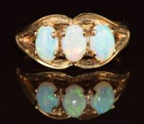 A 9ct gold ring set with three opals, 3.1g, size J