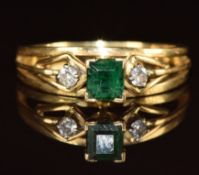 An 18ct gold ring set with an emerald cut emerald of approximately 0.45ct and two diamonds, 3.7g,