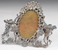 Victorian hallmarked silver oval photograph frame, flanked by winged cherubs, with velvet easel