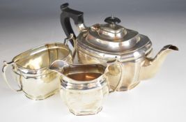 George V hallmarked silver three piece tea set of bulbous rectangular form with incuse corners,