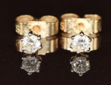 A pair of 9ct gold earrings each set with a round cut diamond, the total diamond weight
