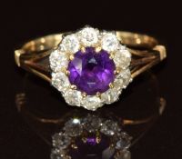 An 18ct gold ring set with a round cut amethyst surrounded by old cut diamonds, in antique box, 3.