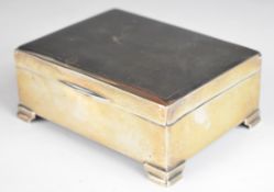 Elizabeth II hallmarked silver cigarette box with engine turned lid, raised on stepped feet,