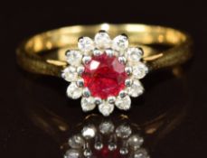 A yellow metal ring set with a round cut ruby of approximately 0.4ct surrounded by diamonds, 3.5g,