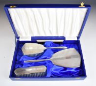 Cased modern hallmarked silver dressing table set comprising hand mirror, two brushes and comb,