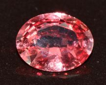 A loose natural pinkish orange oval cut sapphire of approximately 0.95ct, with valuation from Martin