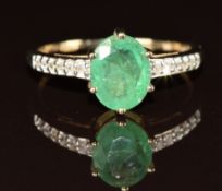 A 9ct gold ring set with an oval cut emerald and diamonds to the shoulders, 2.2g, size R/S