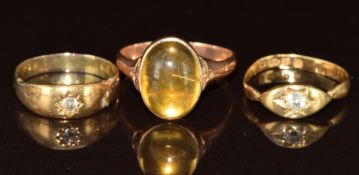A 9ct rose gold ring set with a foiled cabochon (2.7g), a yellow metal ring set with a diamond (1.
