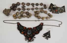 A suite of white metal filigree jewellery comprising brooch/ pendant, two bracelets and necklace and