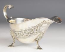 George V Irish hallmarked silver sauce boat with Celtic style decoration and scroll handle, raised