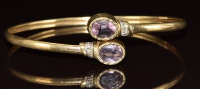 A 9ct gold bangle set with an two oval cut amethysts and diamonds, 8.4g