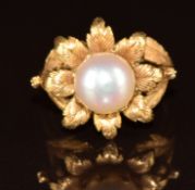 An 18k gold ring in the form of a flower set with a cultured pearl, 7.8g, size K