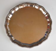 Elizabeth II hallmarked silver salver with shaped and gadrooned edge, raised on three ball and
