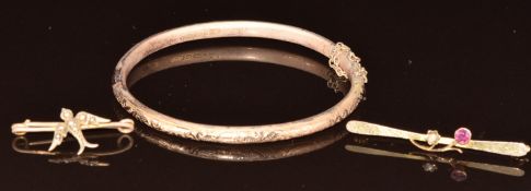 A 9ct gold bangle and two 9ct gold Edwardian brooches, one in the form of a swallow set with seed