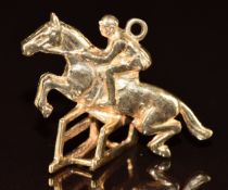 A 9ct gold charm in the form of a horse jumping a hurdle, 4.4g