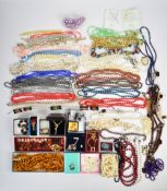 A collection of costume jewellery including beaded necklaces, pearl earrings, pheasant brooch,
