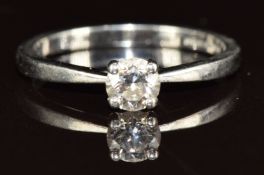 A platinum ring set with a 0.4ct round brilliant cut diamond, with GIA certificate stating colour G,