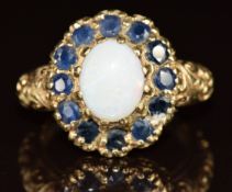 A 9ct gold ring set with an opal surrounded by sapphires, 4.9g, size M