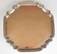 Elizabeth II hallmarked silver salver with shaped edge, raised on four scroll feet, with inscription