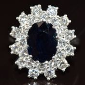 An 18ct white gold ring set with an oval cut sapphire of approximately 3.5ct surrounded by twenty
