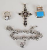 A silver ring with with cubic zirconia, two silver pendants and silver charm bracelet by Judith
