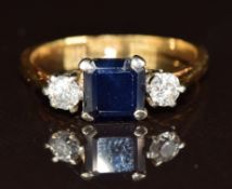 An 18ct gold ring set with an emerald cut sapphire and two diamonds, 3g, size N/M