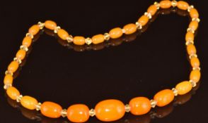A graduated amber necklace interspersed with paste beads, largest amber bead 13.6 x 18.6mm, 16.2g