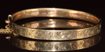 A 9ct gold bangle with engraved scrolling decoration, 9.1g, 5.3 x 6cm