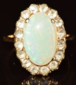 A yellow metal ring set with an opal surrounded by white sapphires, 4.9g, size J/K