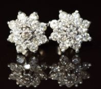 A pair of 18ct white gold earrings each set with a cluster of diamonds, the total diamond weight