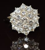An 18ct white gold ring set with a cluster of diamonds in a hexagonal setting, the total diamond