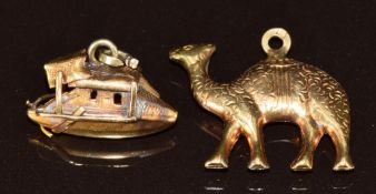 An 18ct gold charm in the form of a camel and a yellow metal charm in the form of a boat, 4.4g