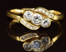An 18ct gold ring set with three diamonds of approximately 0.25ct, 0.12ct & 0.12ct and eight smaller