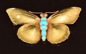 A c1900 gold brooch in the form of a butterfly set with five turquoise cabochons and two old cut