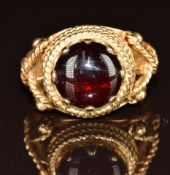 A 9ct gold ring set with a garnet cabochon, 4.9g, size N