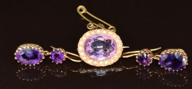 Edwardian yellow metal brooch set with an oval cut amethyst surrounded by seed pearls and a pair