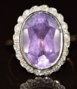 A 9ct gold ring set with an oval cut amethyst surrounded by diamonds, 4.8g, size M