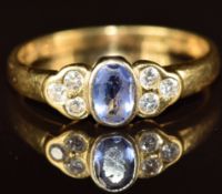 An 18k gold ring set with an oval tanzanite and six diamonds, 3.4g, size P