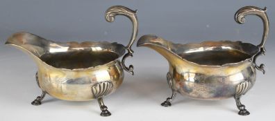 Pair of Georgian hallmarked silver sauce boats with scroll handles, raised on three hoof feet,