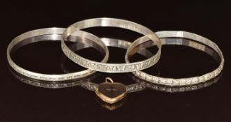 Three silver (800 grade) bangles (28g) and a 9ct gold back and front locket