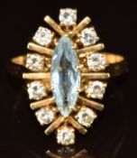 An 18ct gold ring set with a marquise cut aquamarine surrounded by ten diamonds, 5.9g, size T
