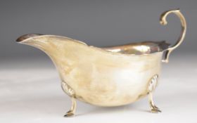 George V hallmarked silver sauce boat with shaped edge and scroll handle, raised on three feet,